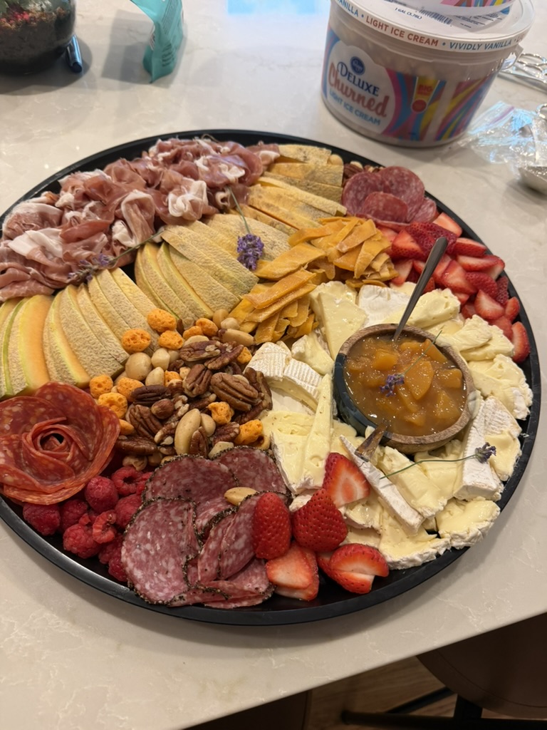 Charcuterie platter with cheeses, fruit, nuts, and preserves